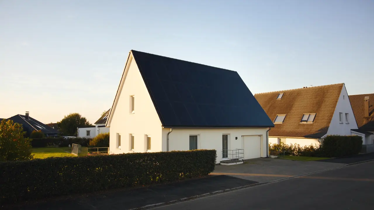 Einfamilienhaus mit vollflächig belegtem Solardach im Nachmittagslicht